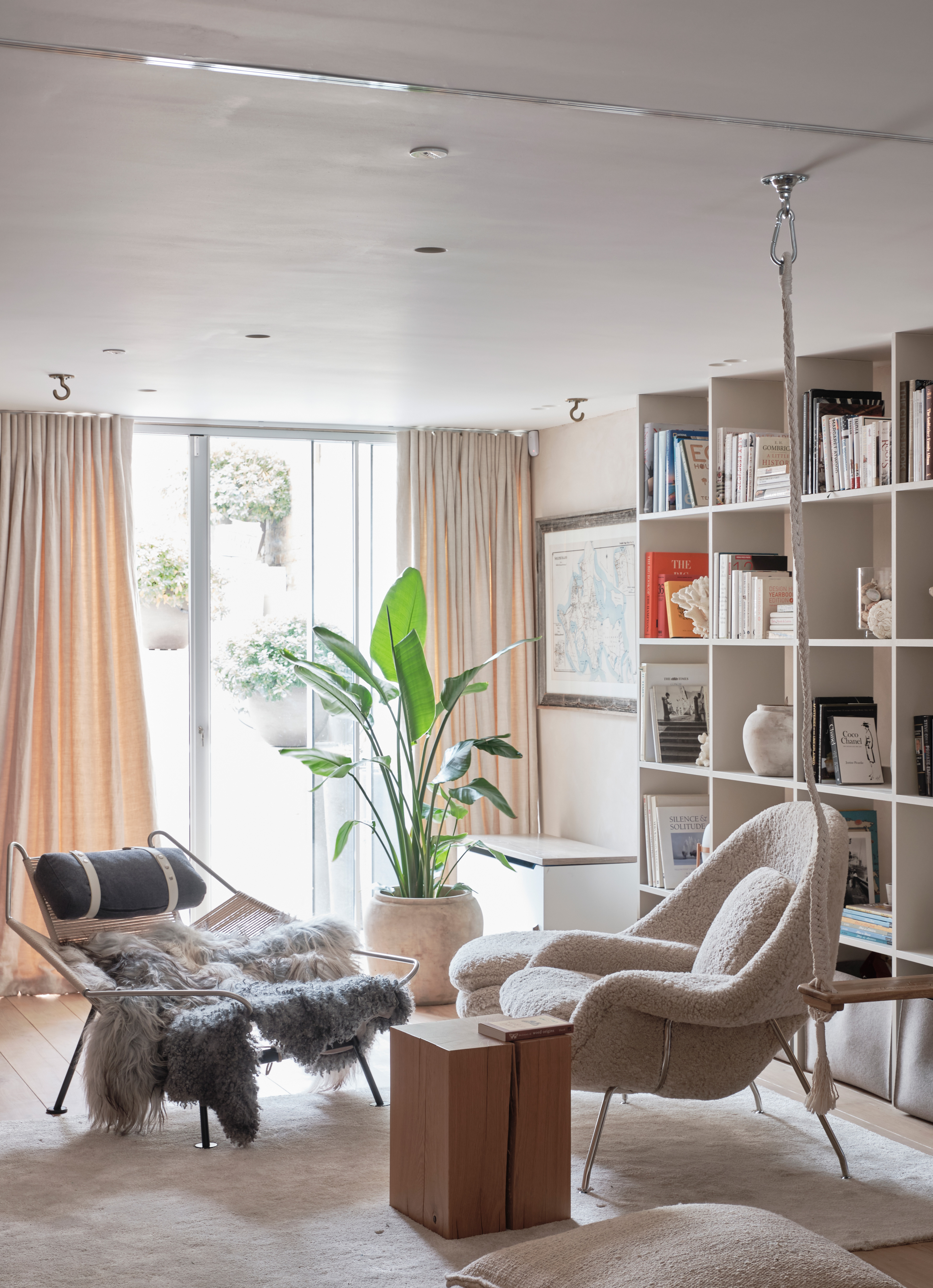 Neutral living room with mis matching arm chairs and wall of storage