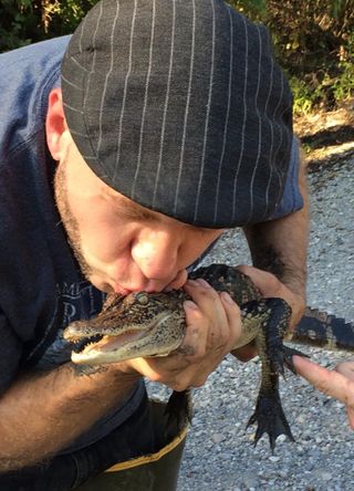 Brandon Ballengée with a baby alligator.