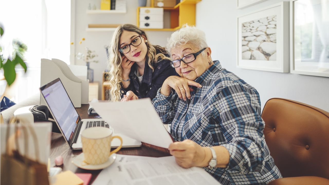 Two business owners go over paperwork at a desk.