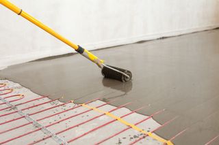 Screed being laid over electric underfloor heating wires