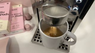 picture of the coffe machine dispensing coffee into white mug