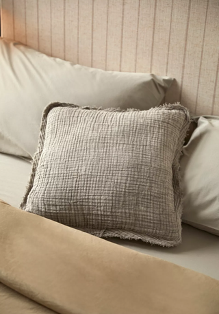 textured throw pillow on a minimal bed