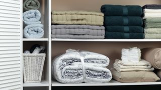 Linen Closet with folded seat cushions, blankets and towels