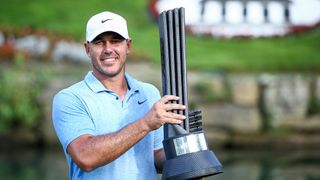 Brooks Koepka holds a LIV Golf trophy