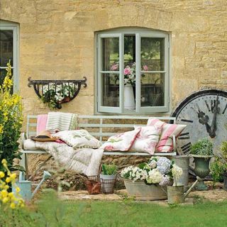 pretty country garden with seating bench and throws