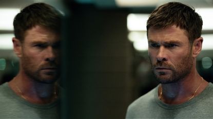 Chris Hemsworth's Davis looking out of a window at his own reflection in Crime 101
