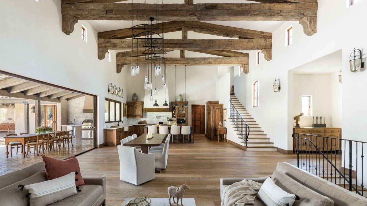  open plan living kitchen diner with ceiling beams and staircase plus outdoor dining space