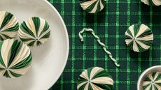 green and white paper Christmas baubles on a green grid-patterned tablecloth