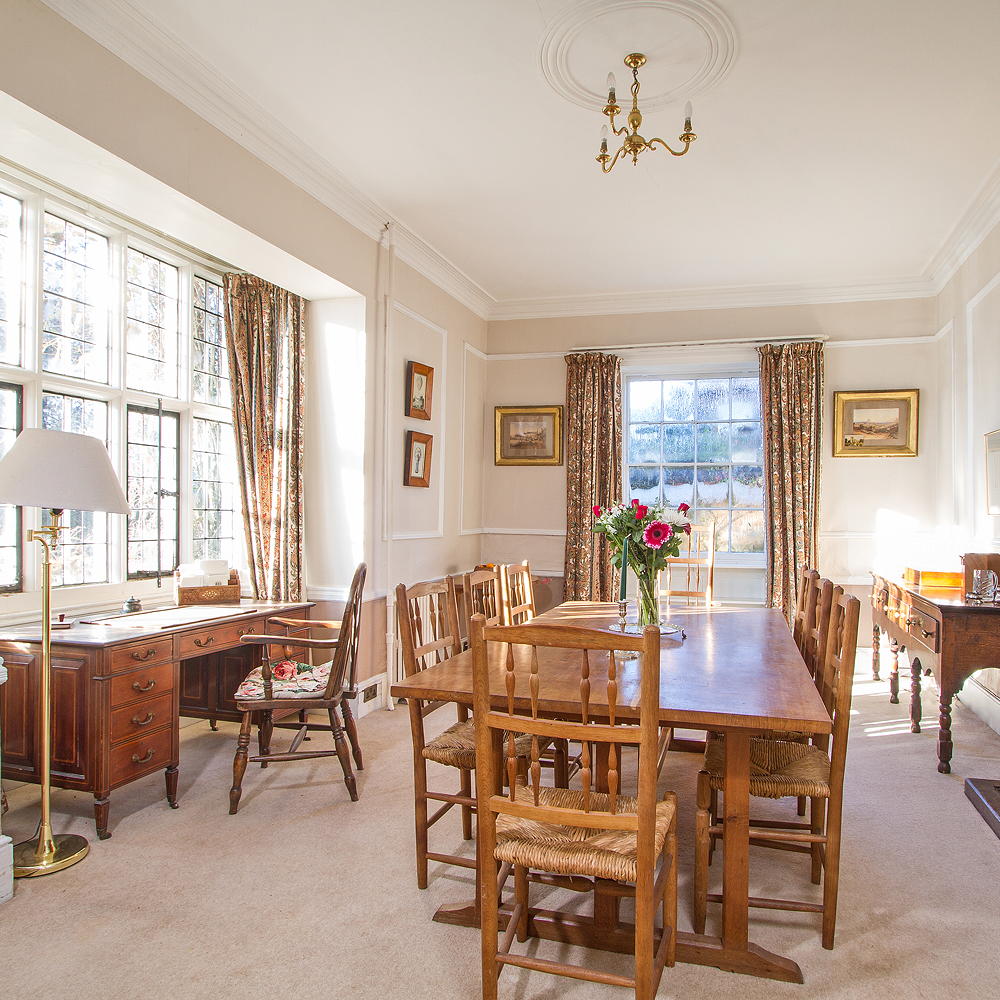 dining area with white wall and wooden dining table with chairs