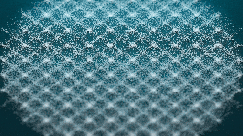 geometric designs form and change in sand on a green background