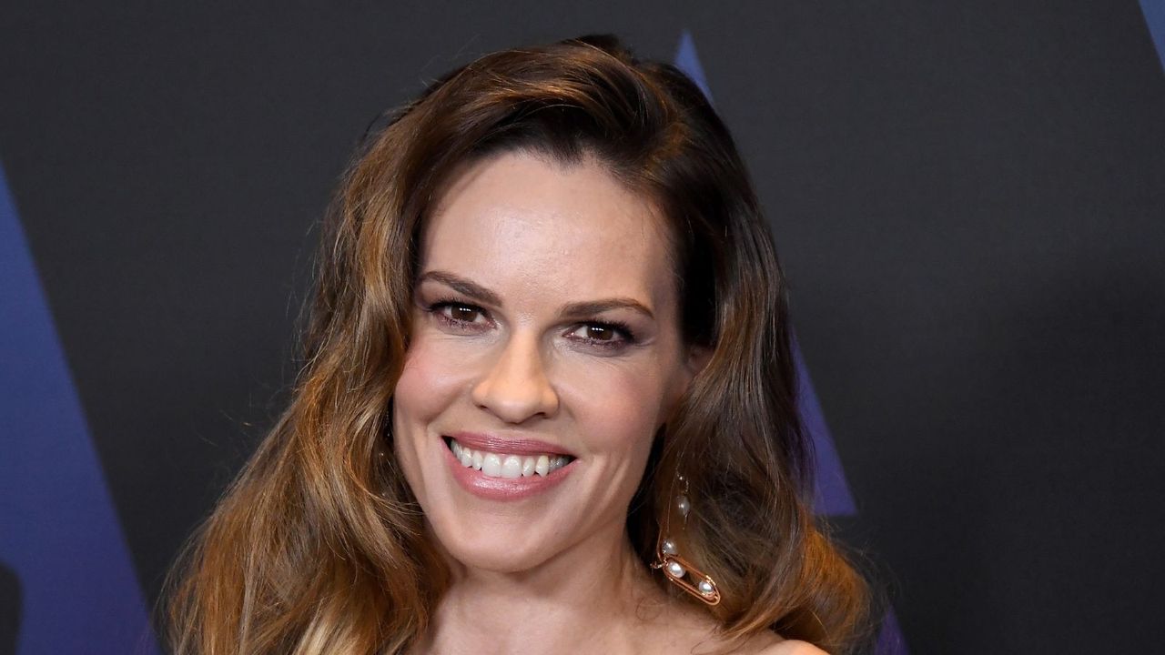 hilary swank on a black and blue background