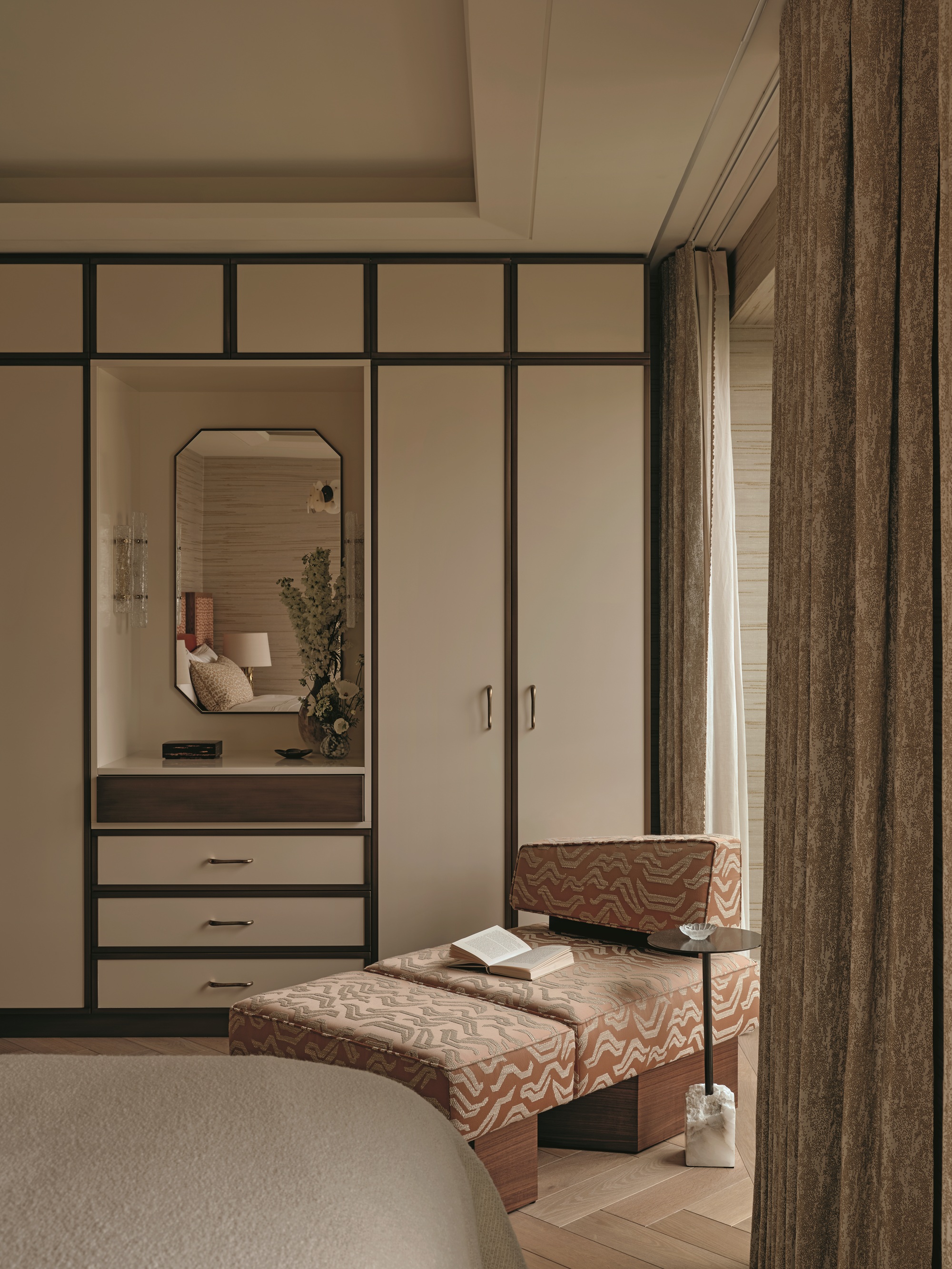 a bedroom with a low slung chair with a footstool in an orange tiger pattern