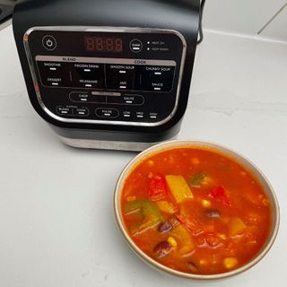 Ninja Foodi HB150UK Blender and Soup Maker next to chunky tomato soup in bowl