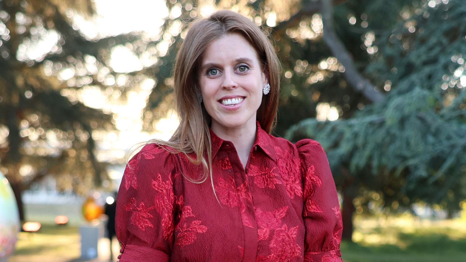 Princess Beatrice, wearing a red maxi dress, smiles as she attends The Elephant Family Evening of Art and Conservation at Kew Gardens on May 13, 2025