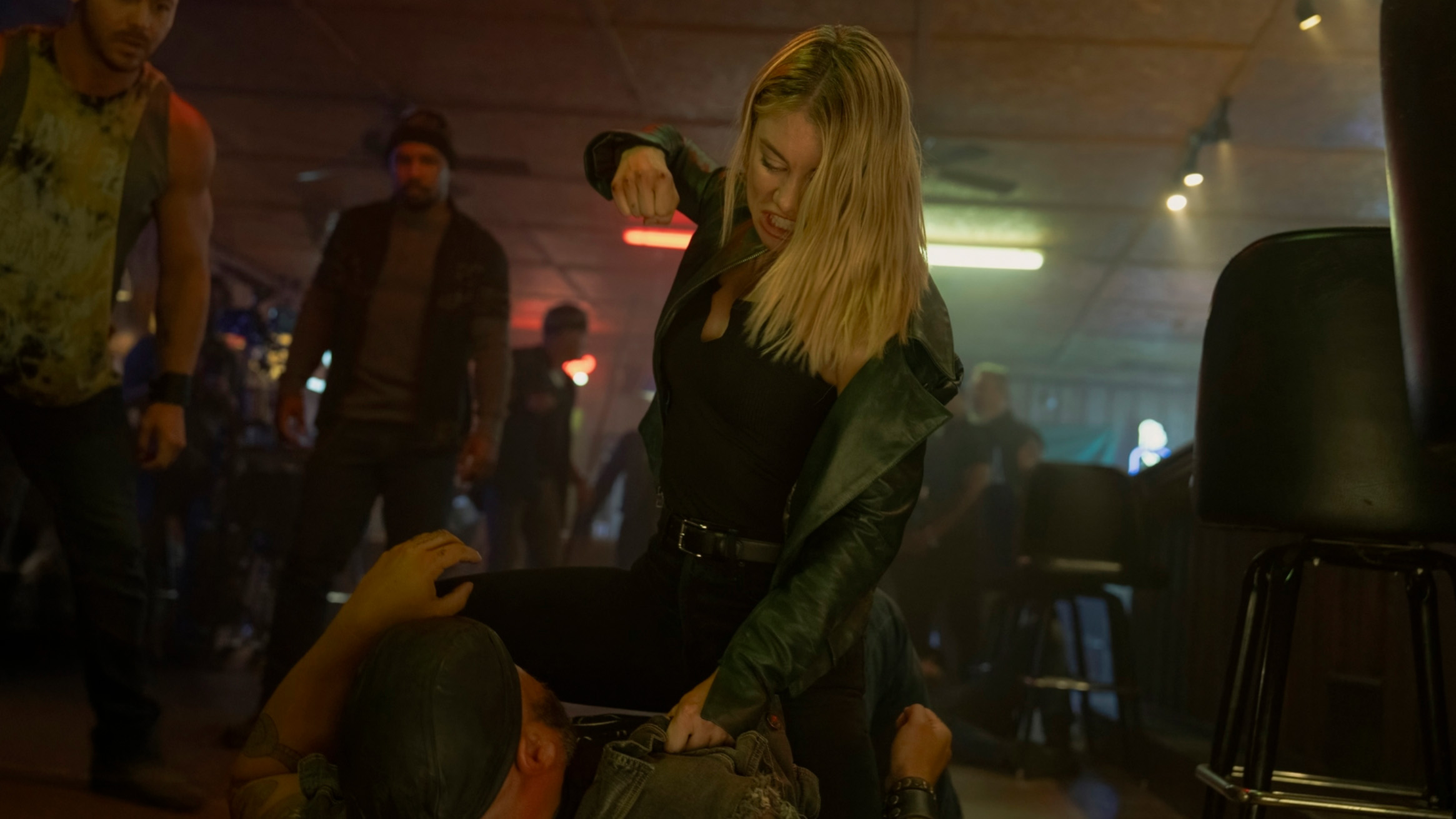 Harcourt (played by Jennifer Holland) beats up some thugs in episode one of Peacemaker season 2.