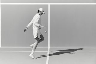 Woman on tennis court in Brunello Cucinelli tennis whites photographed in black and white