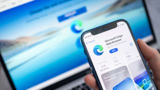 Microsoft Edge open on a laptop with the browser's app listing page open on a smartphone in front of it