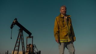 Tommy Norris looks weary and hot as he stands in an oil field in Paramount Plus' Landman TV series