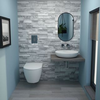 Grey brick effect wall with wall hung toilet and sink and mirror