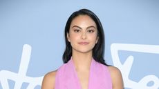Camila Mendes wearing pink in front of pale blue wall