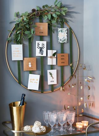 Green living room with gold bar cart and gold hoop Christmas card holder