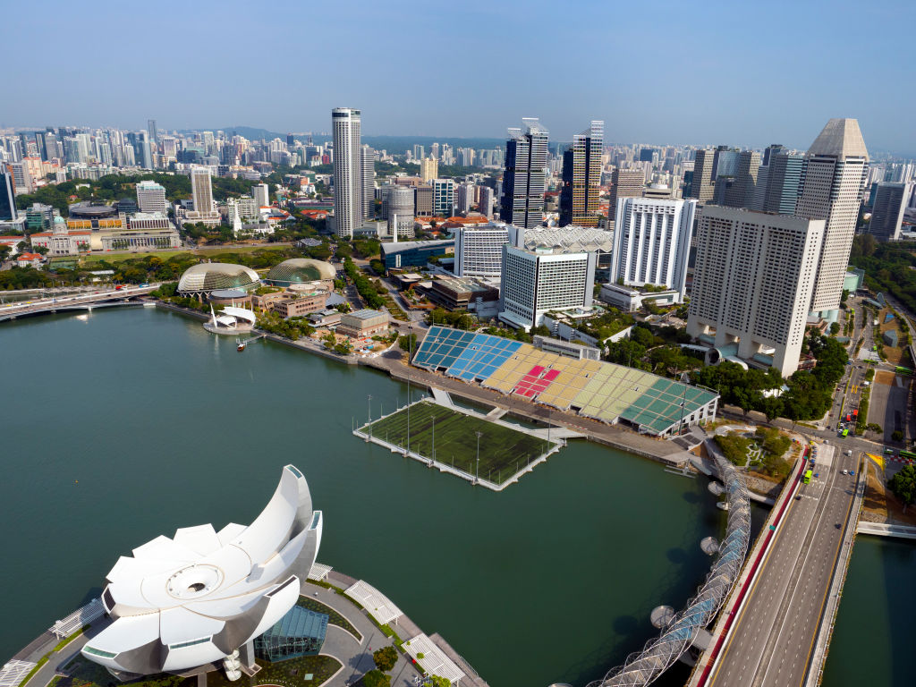 Distintivamente a forma di fiore di loto che si apre, l'ArtScience Museum di Singapore è un'icona architettonica moderna, situata di fronte alla costa di Marina Bay, nel centro della città.  Qui lo vediamo visto, insieme al ponte elicoidale, all'Esplanade e al Galleggiante da un punto di osservazione sopraelevato.