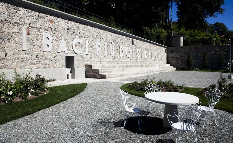 Public space with pebbles. greenery and white table and chairs