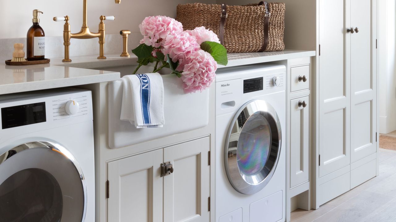 washing machine in utility area with sink and pink hydrangeas