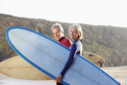 A man and a woman on the beach with surfboards 