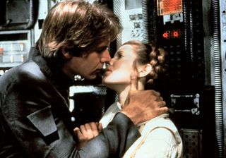 Harrison Ford and Carrie Fisher share a kiss aboard his ship the Millennium Falcon