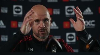 Close-up shot of Manchester United manager Erik ten Hag giving a press conference, making a hand gesture
