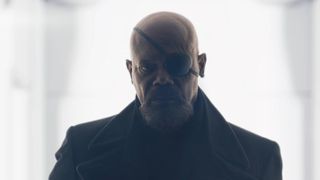 Samuel L Jackson's Nick Fury sports his iconic eyepatch and long coat as he exits a well-lit white room in Secret Invasion