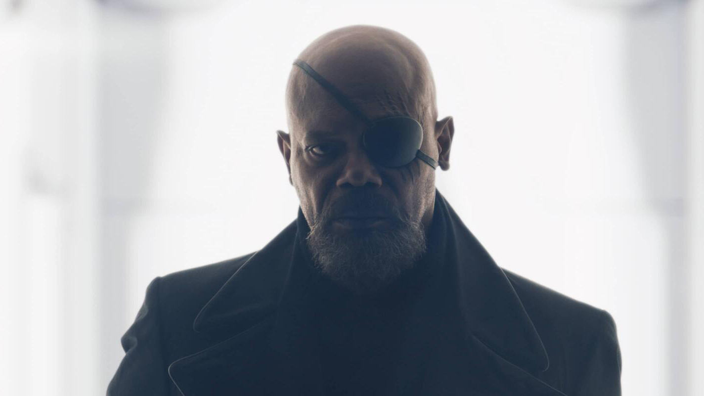 Samuel L Jackson's Nick Fury sports his signature eye patch and long coat as he steps out of a brightly lit white room in Secret Invasion