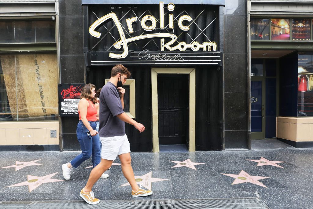 People walk outside a closed bar in Hollywood.