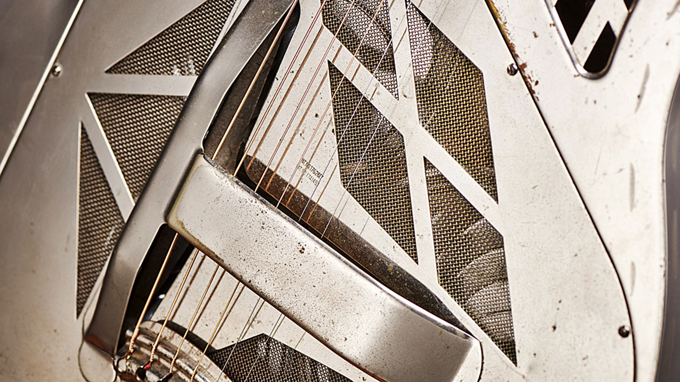 Three aluminium amplifying cones open towards the back of the instrument and these are joined by an aluminium bar that sits underneath the bridge. This can be clearly seen through the mesh-covered split‑diamond soundholes
