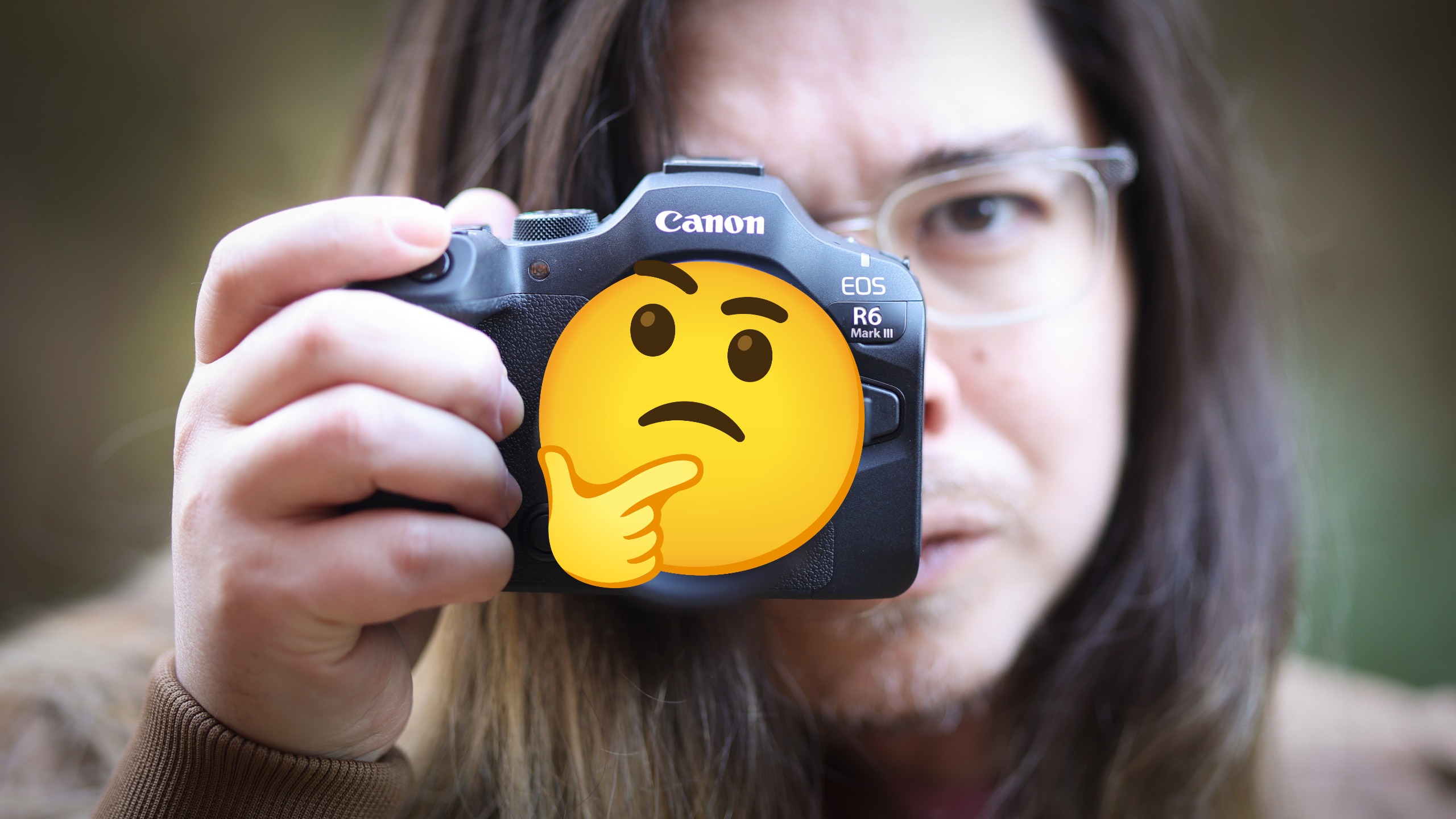 Photographer holding a camera with the "Hmm" emoji on the end of the lens