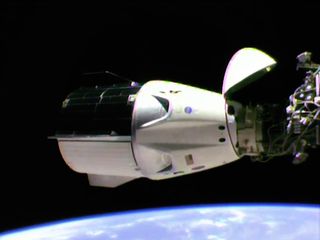 A Crew Dragon capsule approaches the International Space Station during the uncrewed Demo-1 flight test.