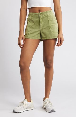 a model wears green shorts with white sneakers