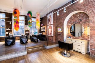 Brick wals and fuzzy hanging sculptures at Suite Caroline New York hair salon