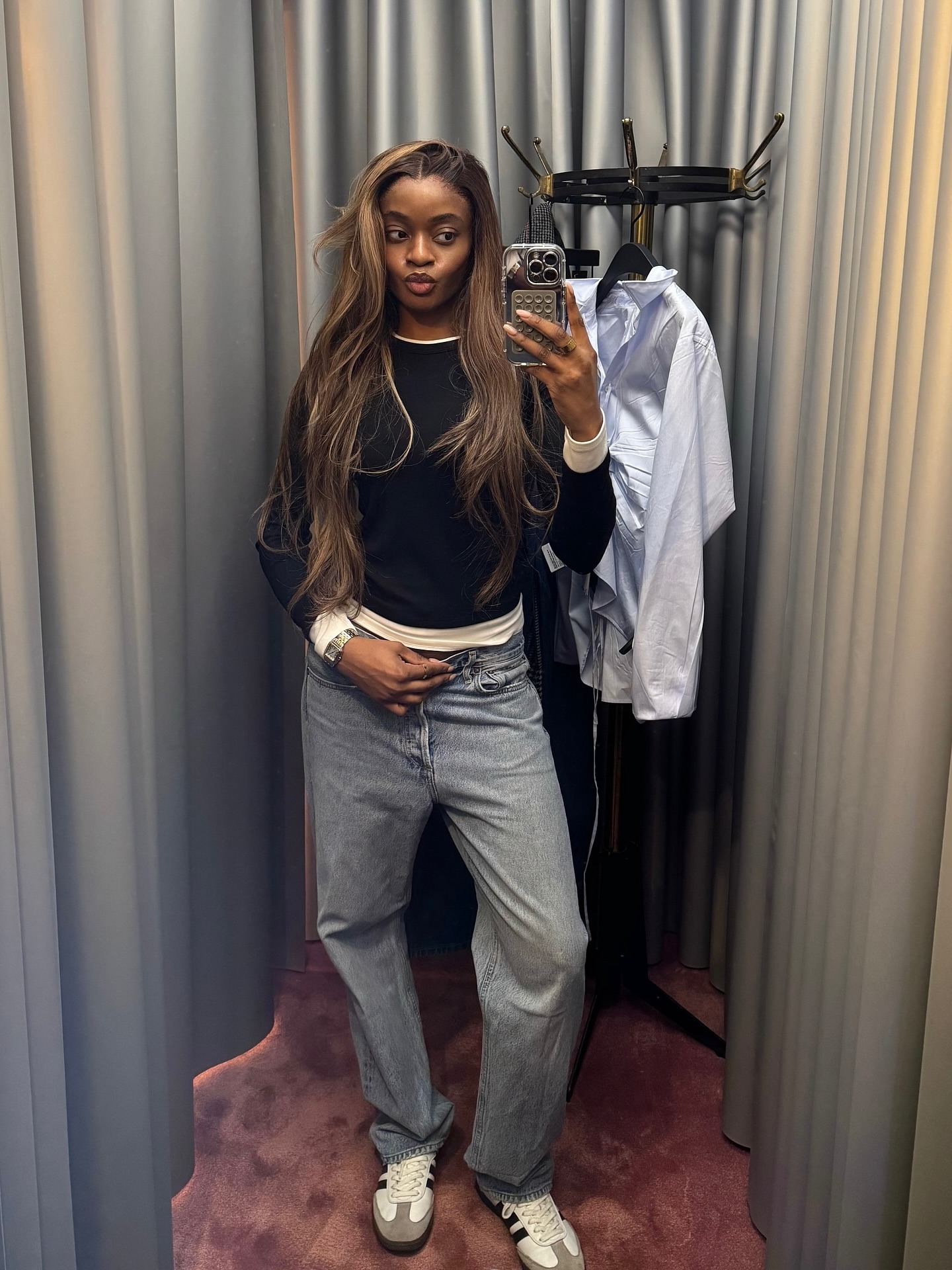 @mimi.orere wearing a jeans, a black long-sleeve, and Adidas sneakers