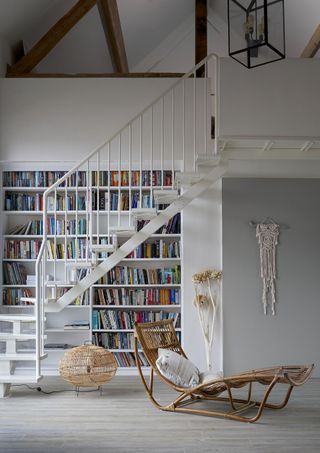 hallway with books and white modern staircase