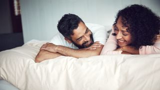 couple lying in bed together laughing