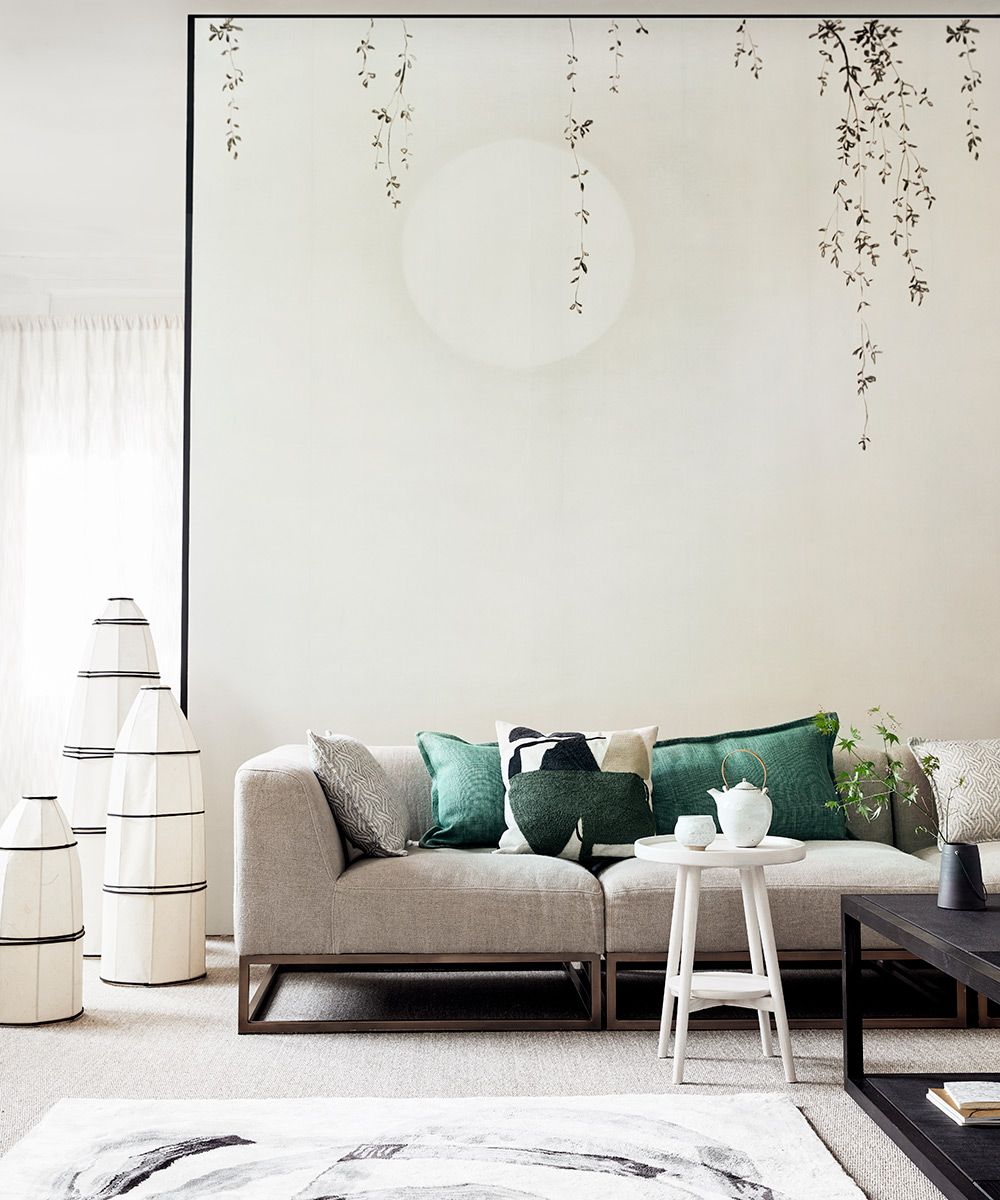 Japanese style living room picture with neutral walls and sofa and green cushions.