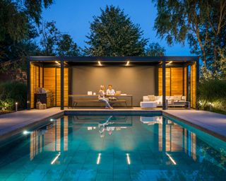 modern pergola with lights by pool, designed by Garden House Design