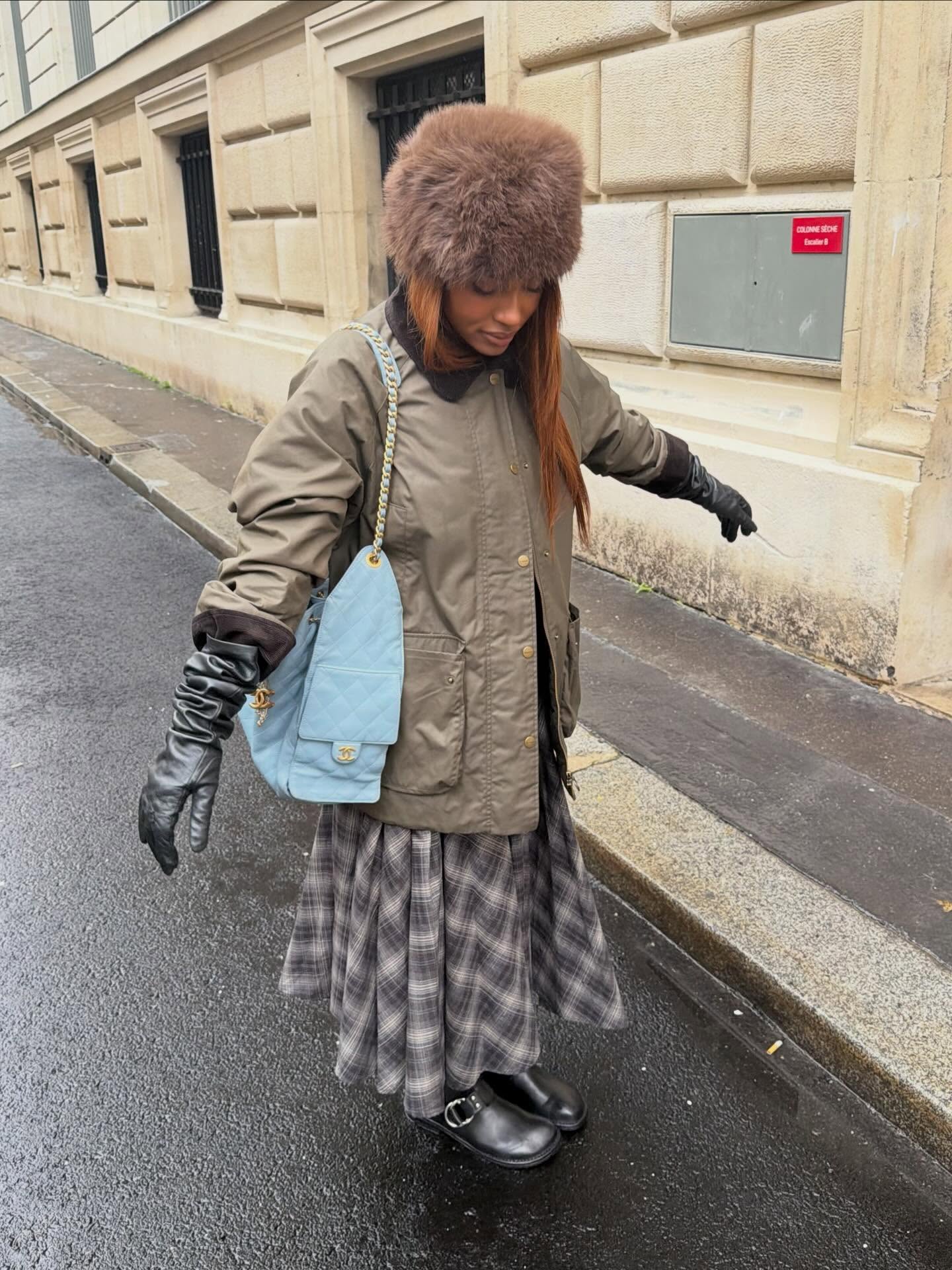 @mv.tiangue in a barn coat, plaid skirt, and leather gloves, wearing the faux-fur hat trend