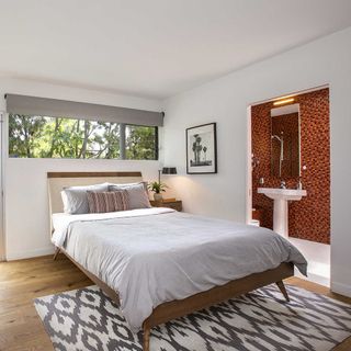 bed with white wall and wooden floor