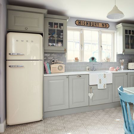 Green country kitchen with cupboards and counter by window