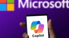 Microsoft Copilot app running on a phone with Microsoft logo in background
