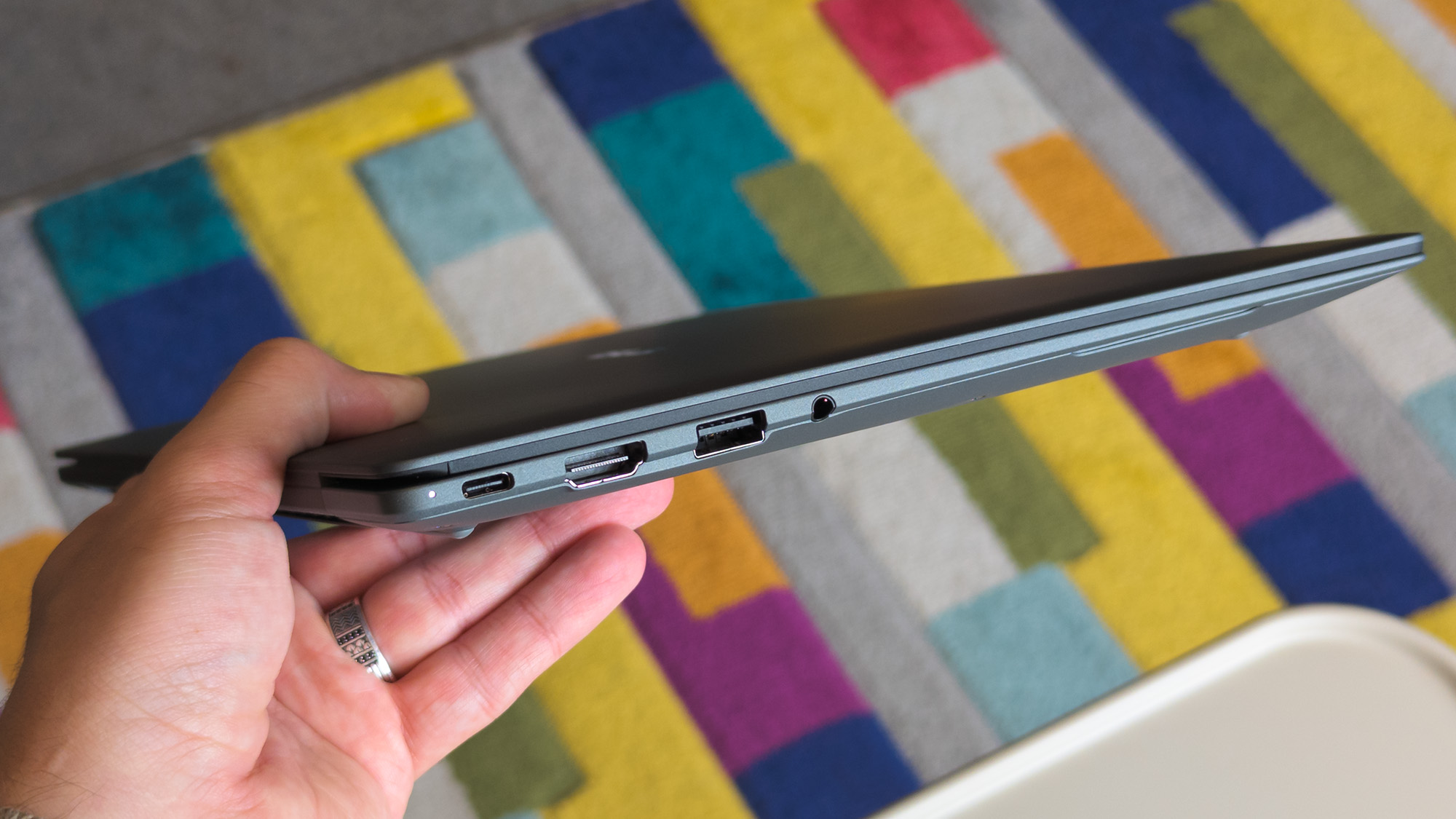 ASUS Googlebook 14 held in hand showing side ports