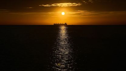 An oil vessel is silhouetted at sunset in the Caribbean Sea, near Santa Marta, Colombia